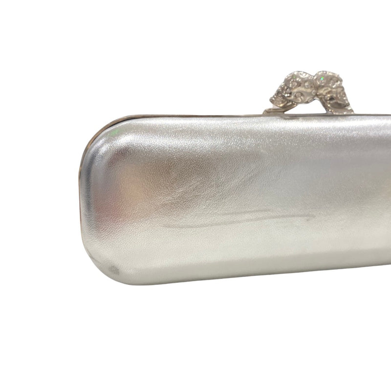 pre-loved ALEXANDER MCQUEEN silver clutch with two diamond-studded skulls on the fastening 