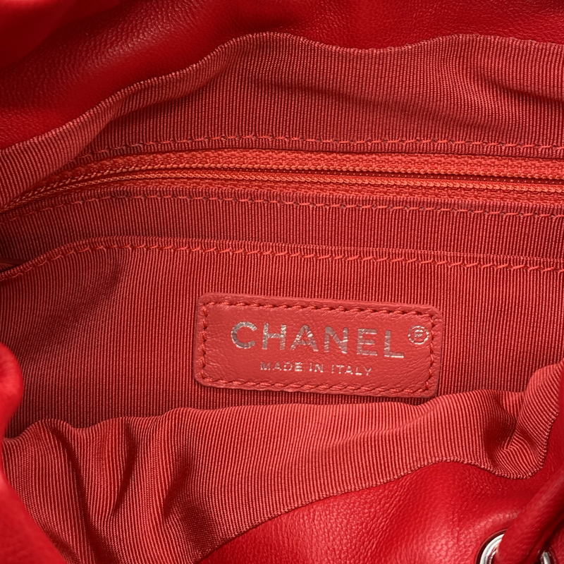 CHANEL bright red grained leather drawstring backpack with metal hardware